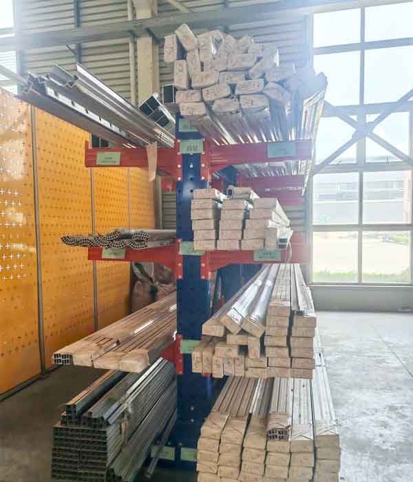 Cantilever rack with red arms storing aluminum extrusion profiles and long tubes in a warehouse